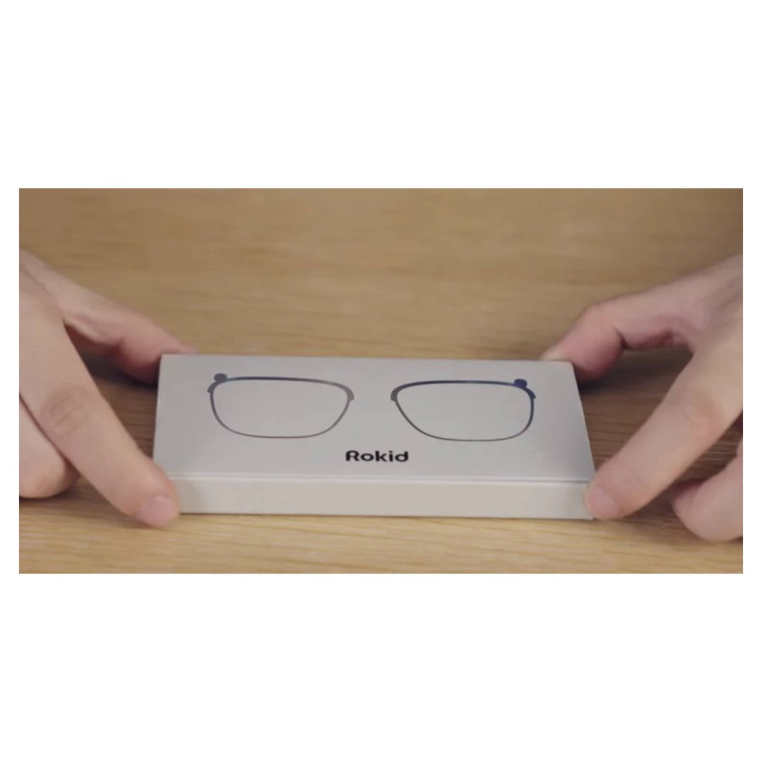 Hands holding a white box with a glasses frame illustration and "Rokid" logo