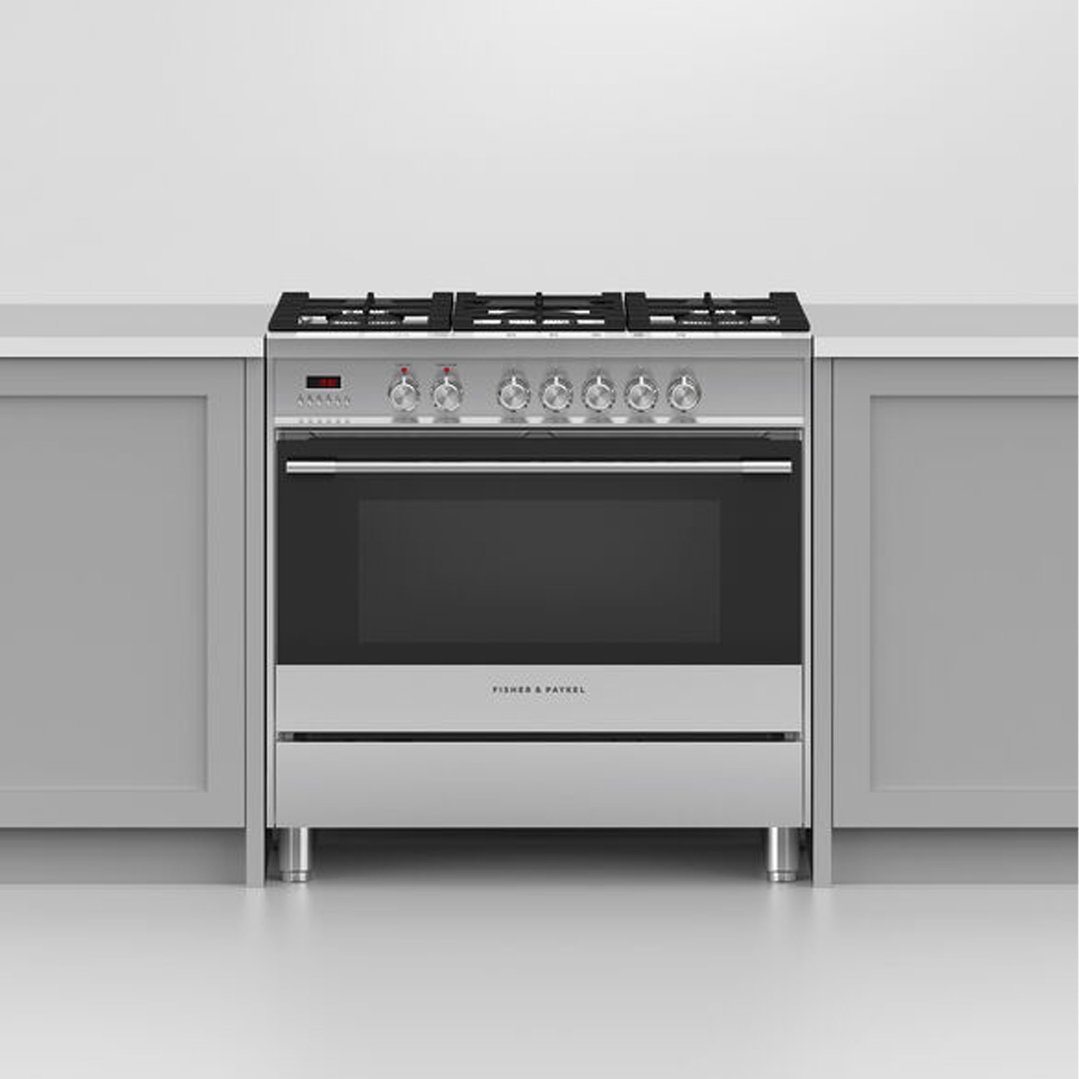 Dual fuel cooker with five burners and oven in a kitchen setting