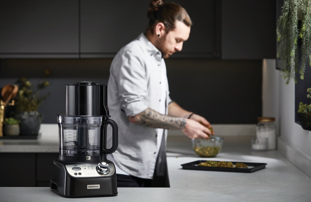 KENWOOD MultiPro XL Weigh+ Food Processor on a counter with a man cooking