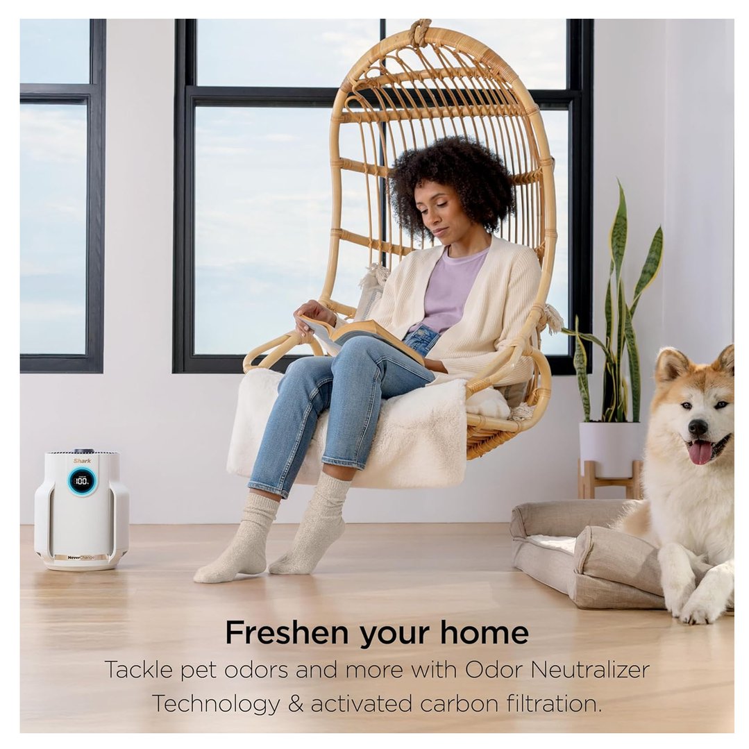 Woman reading in a hanging chair with a SHARK air purifier and a dog nearby