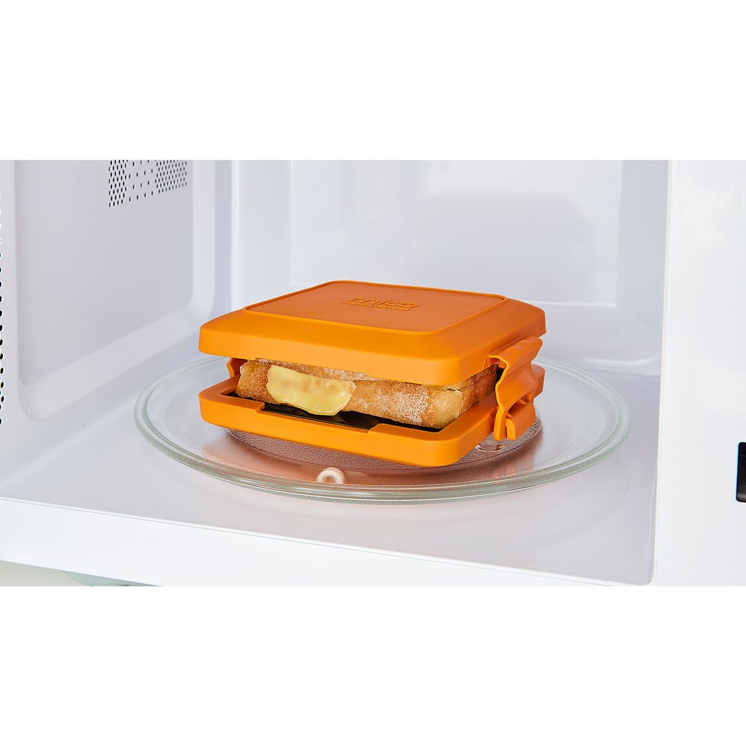 Orange MICO Toastie sandwich maker with a sandwich inside, in a microwave