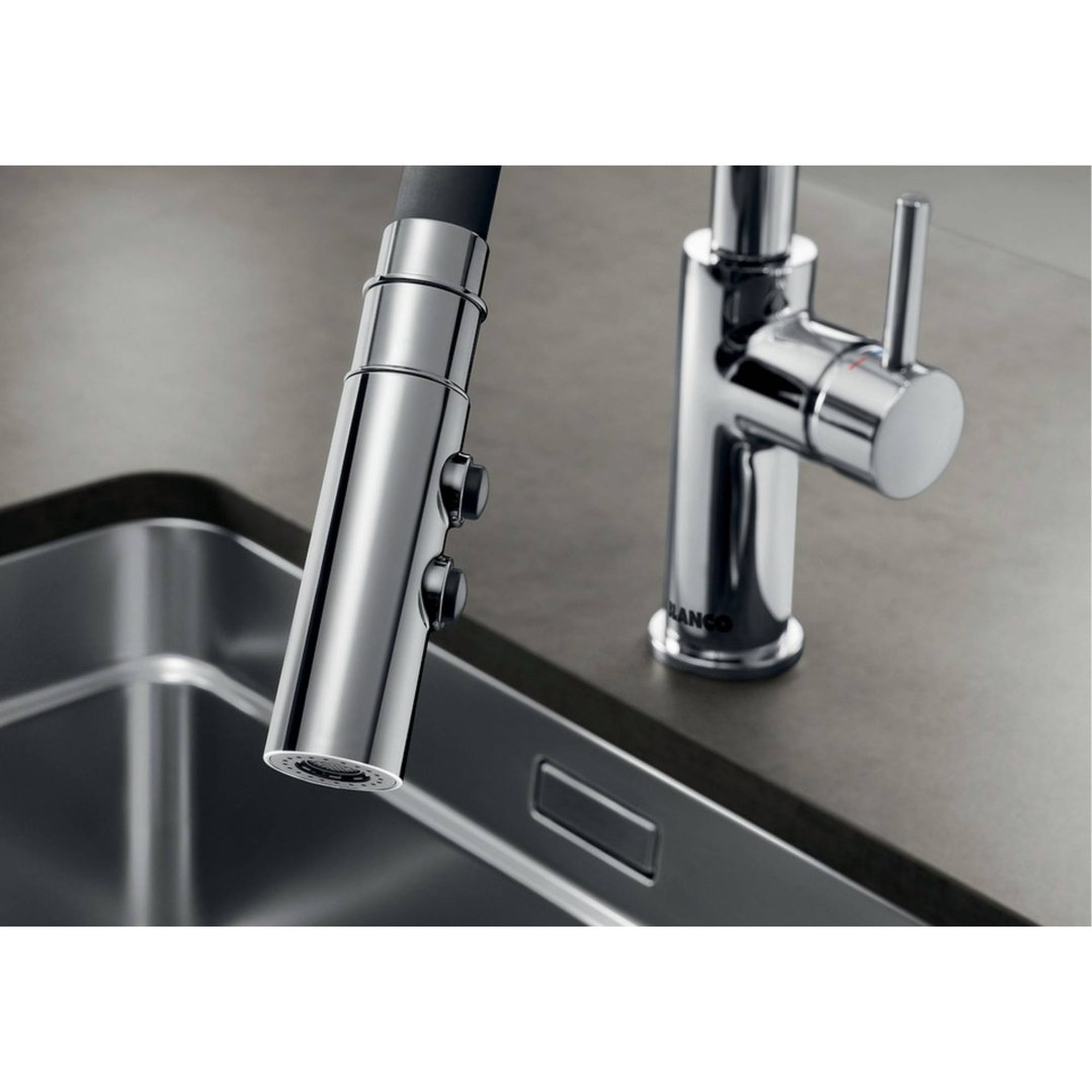 Chrome mixer tap with pull-out spray head over a stainless steel sink
