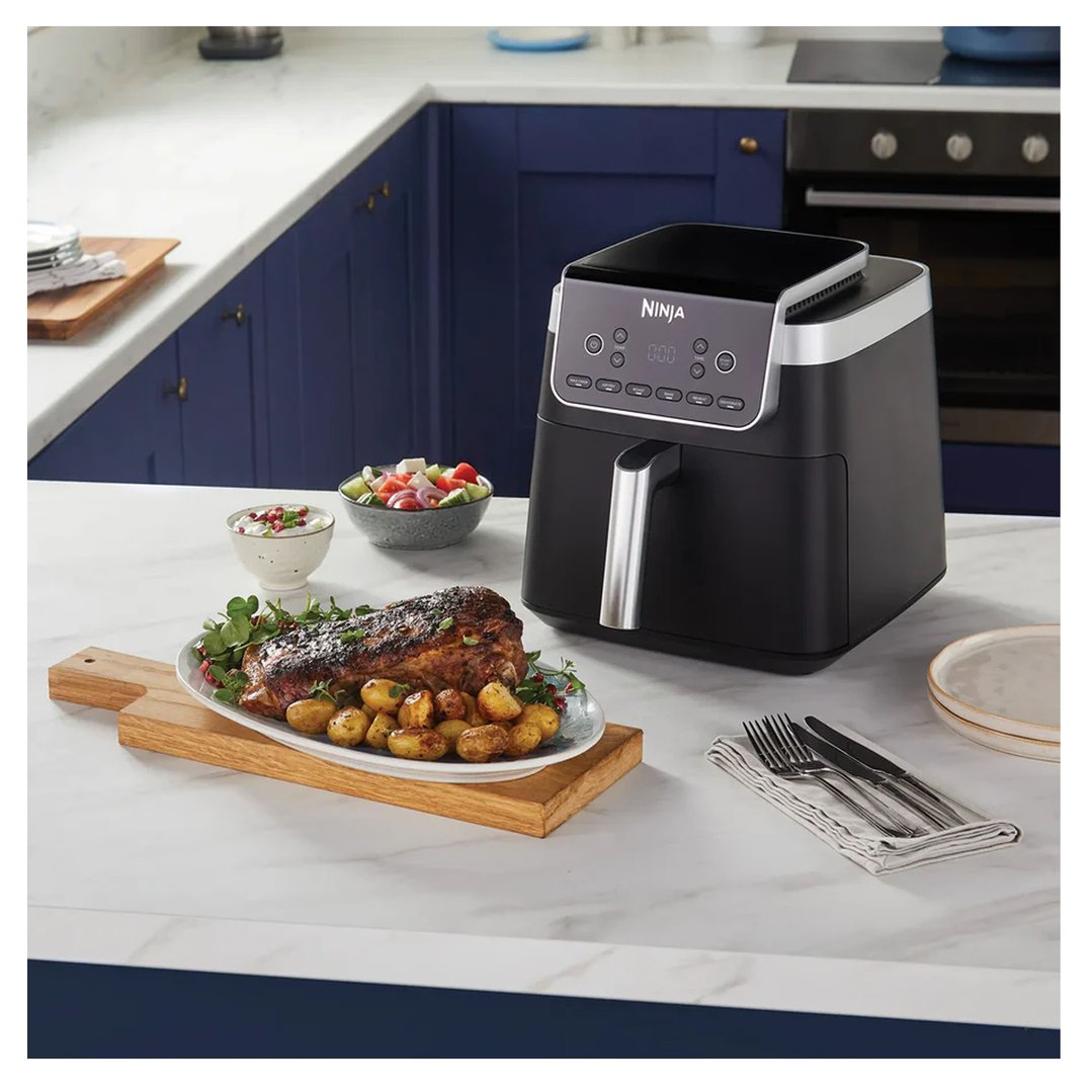Ninja Air Fryer Pro XL on a kitchen counter with a cooked meal