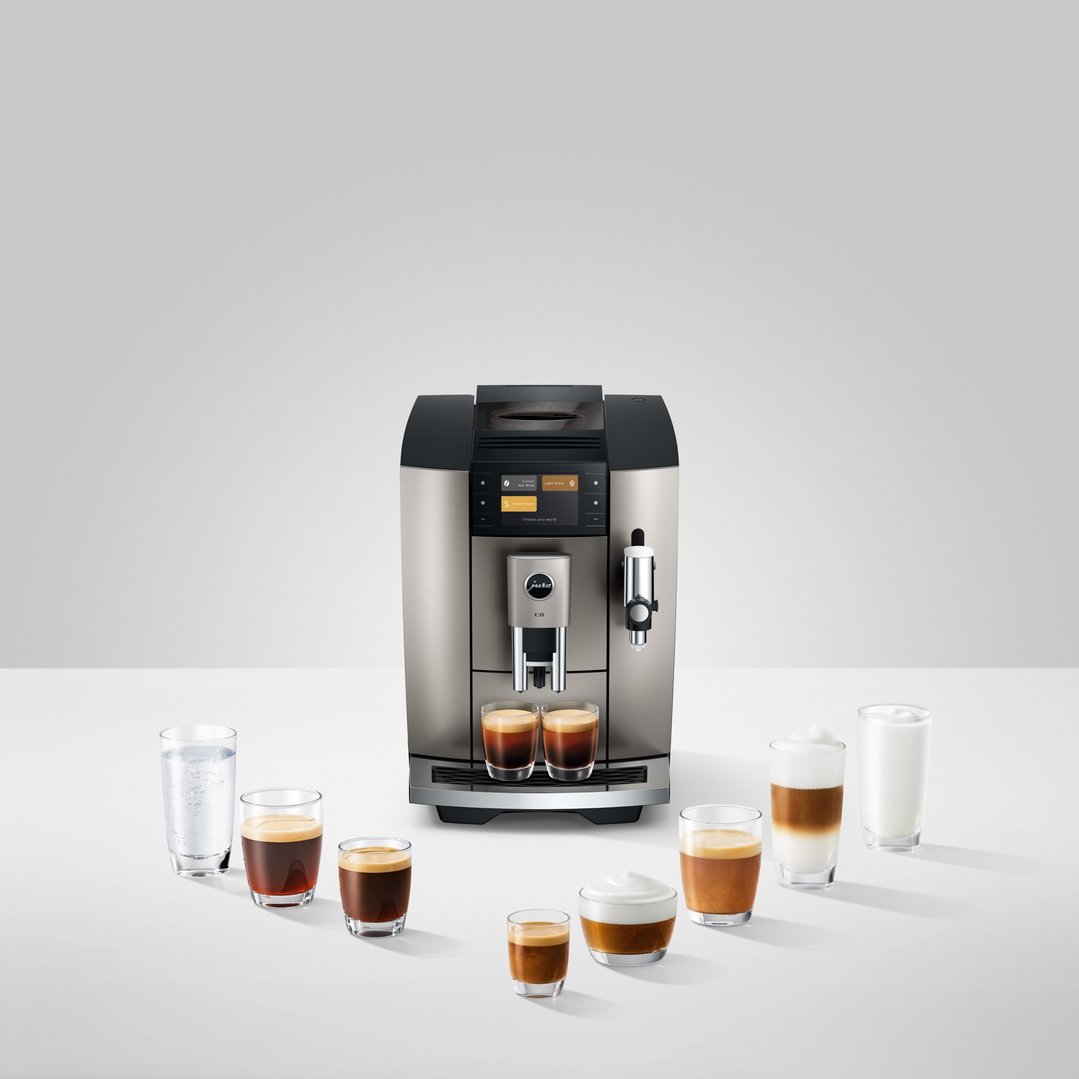 JURA coffee machine with various coffee and milk drinks on a white surface