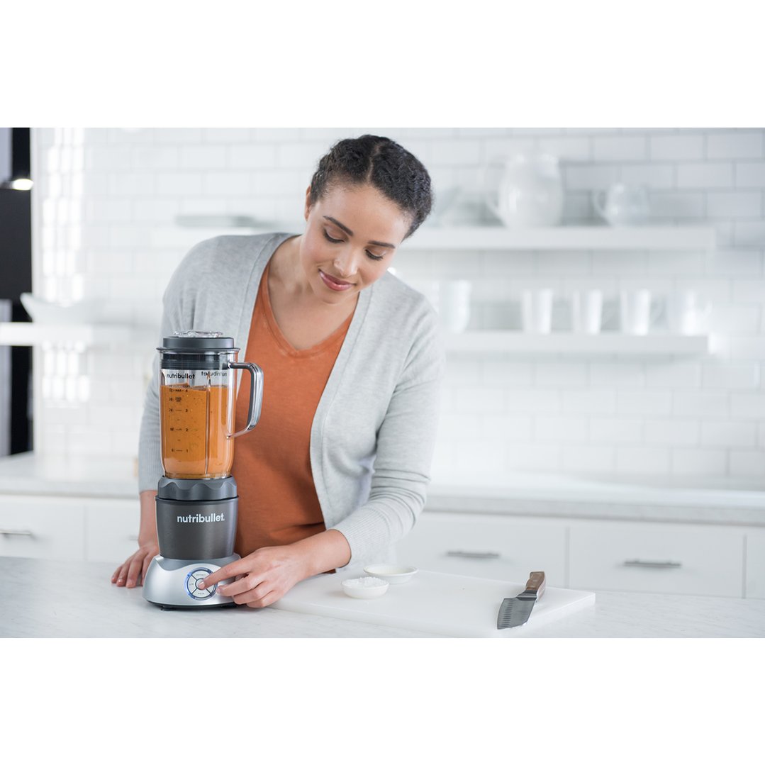 Woman blending a drink in a Nutribullet blender on a kitchen counter