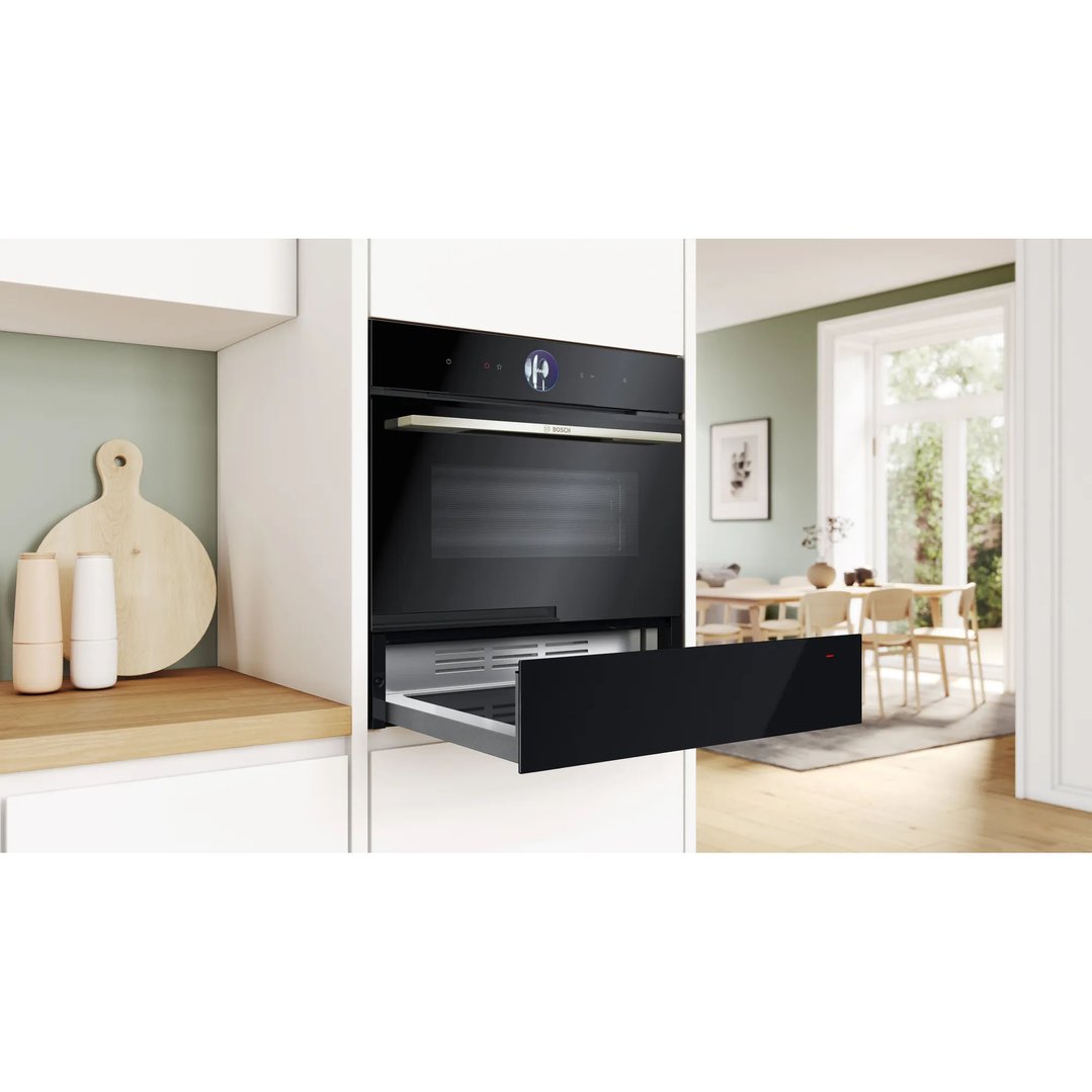 Black built-in oven and warming drawer in a modern kitchen setting