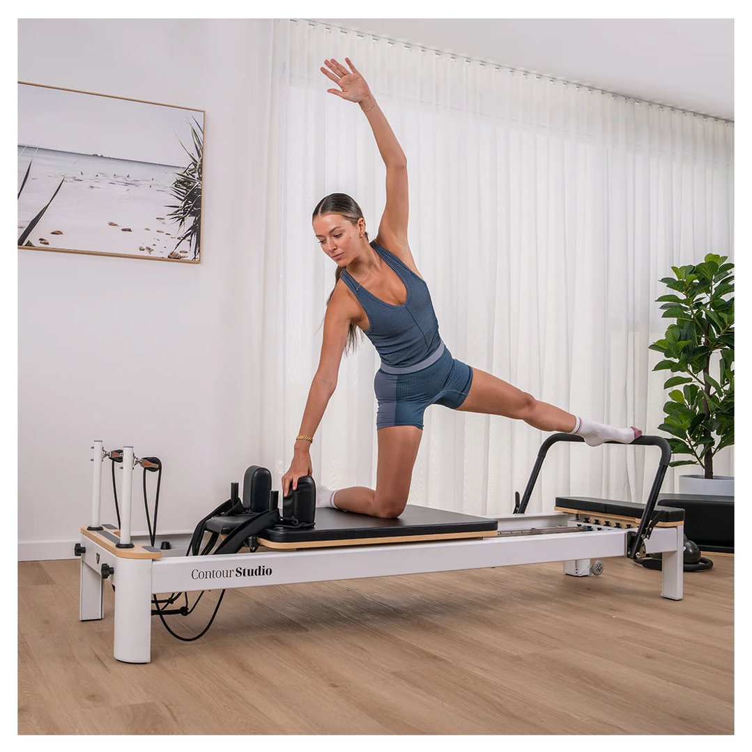 Woman performing pilates on a Reformer Contour Studio Commercial Pilates Set