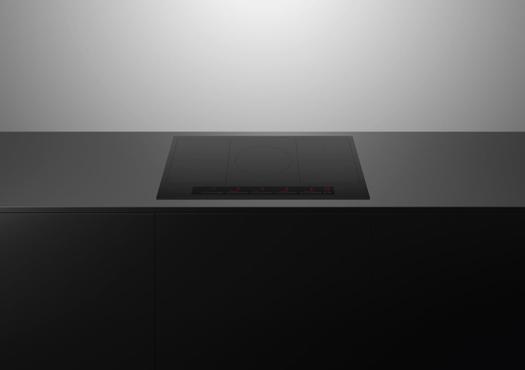 Black 5 zone induction cooktop built into a dark kitchen counter