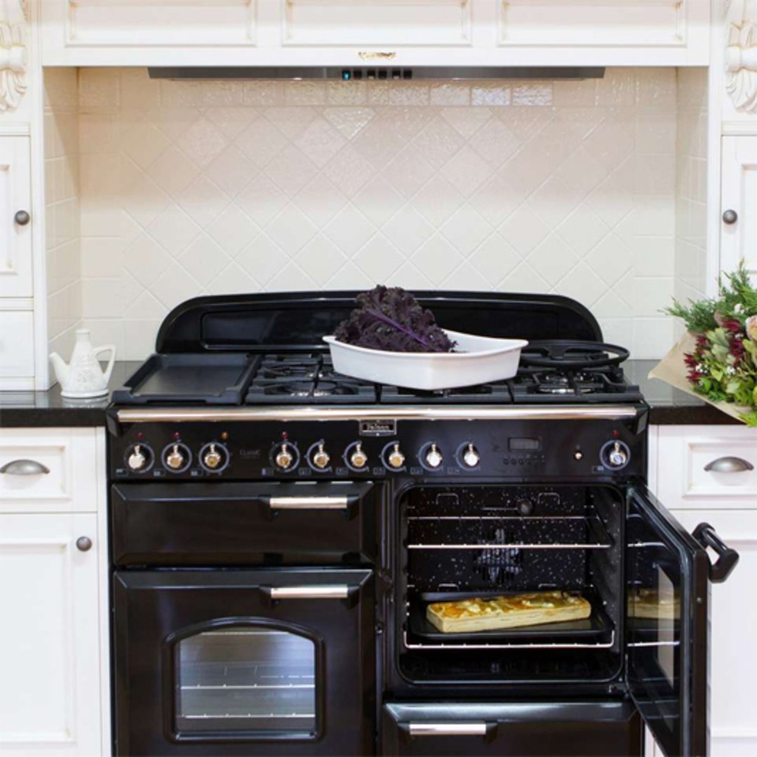Black range cooker with open oven door in a white kitchen setting