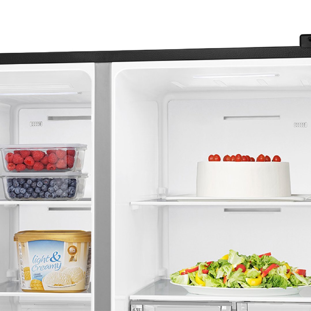 Open fridge interior with berries, ice cream, cake, and salad on shelves