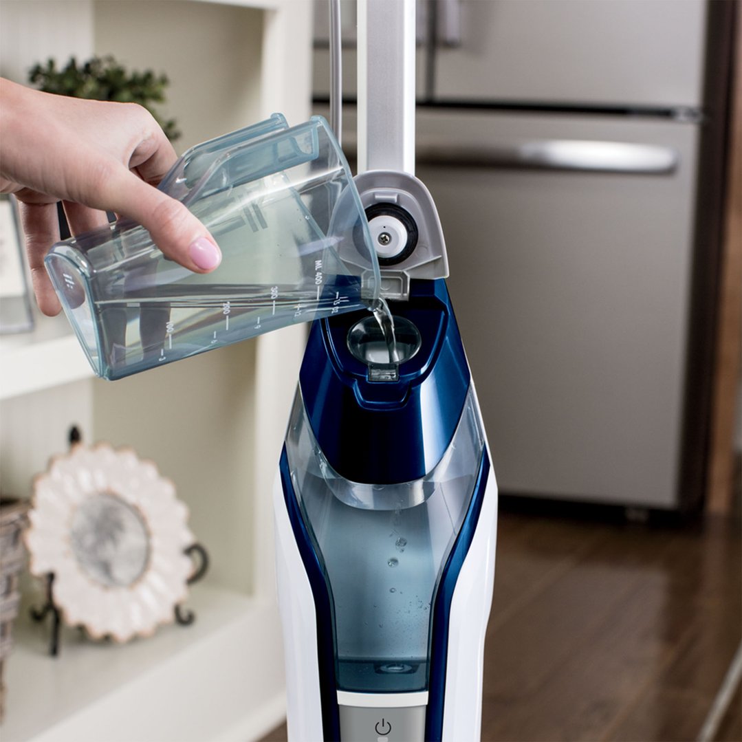 Hand pouring water into the BISSELL PowerFresh Deluxe Steam Mop