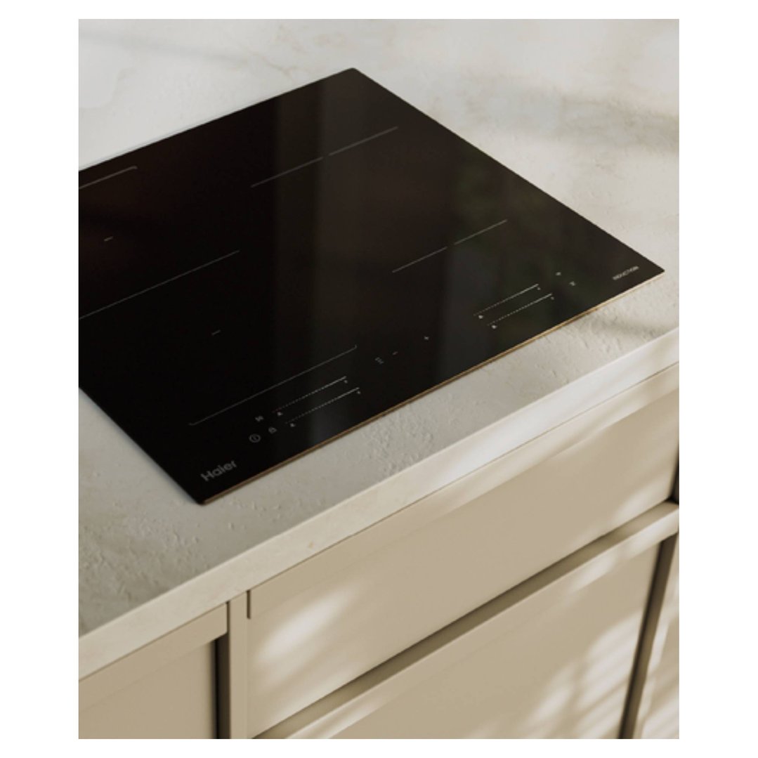 Black induction cooktop built into a light-colored countertop in a kitchen