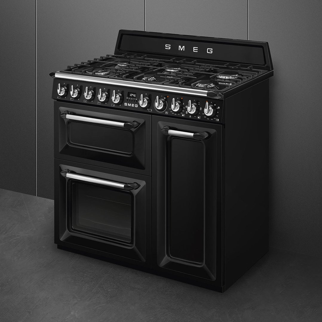 Black freestanding dual fuel oven/stove with gas cooktop in a dark kitchen