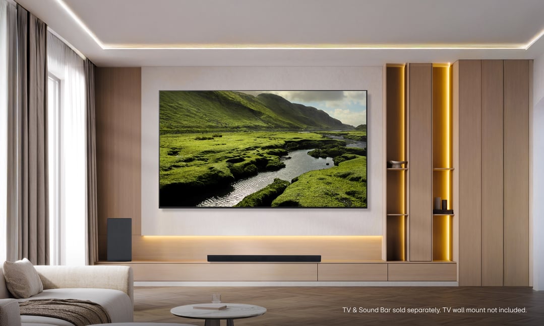 An LG TV wall-mounted in a modern living room with a sound bar below