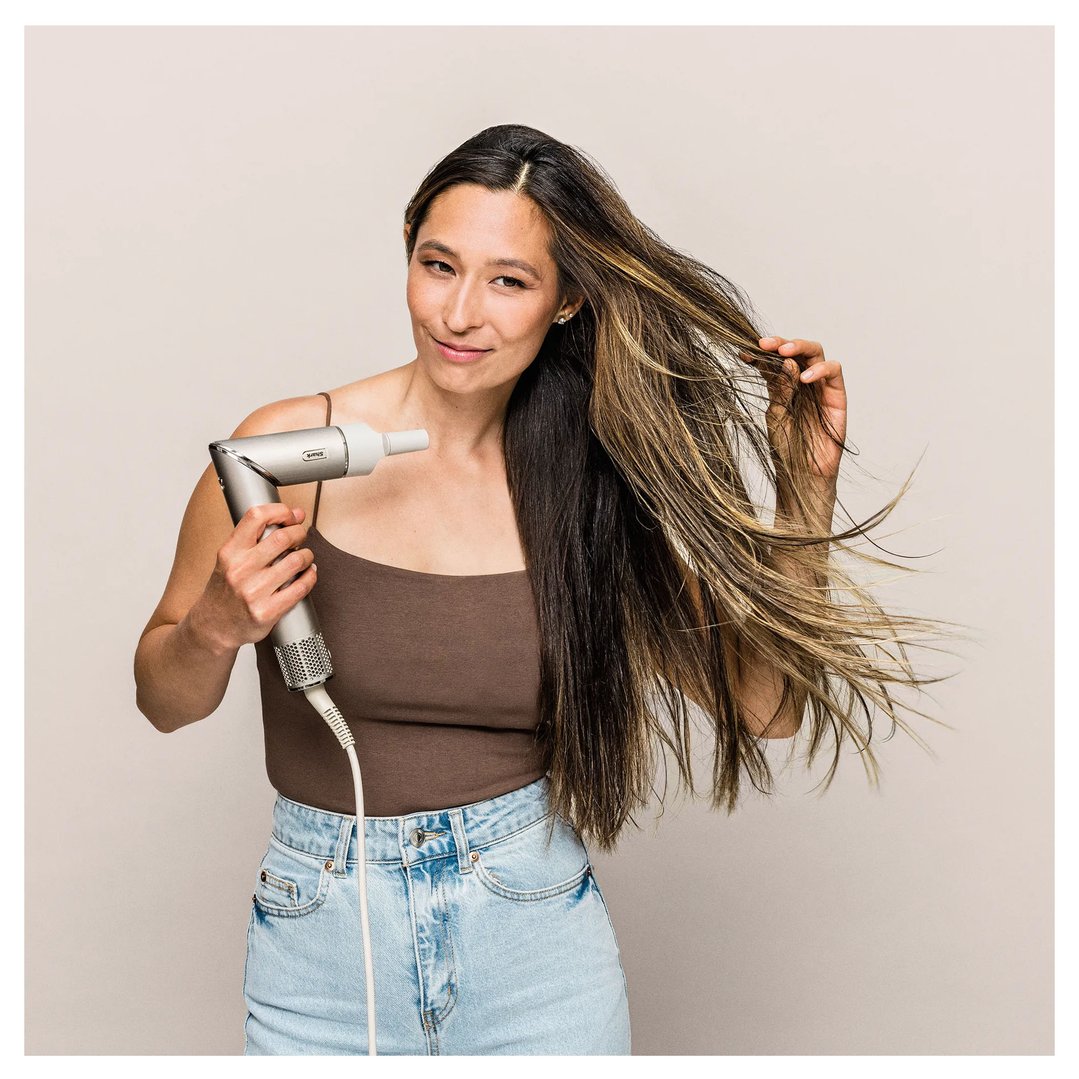 Woman holding a Shark FlexStyle Air Styling & Drying System and styling her hair