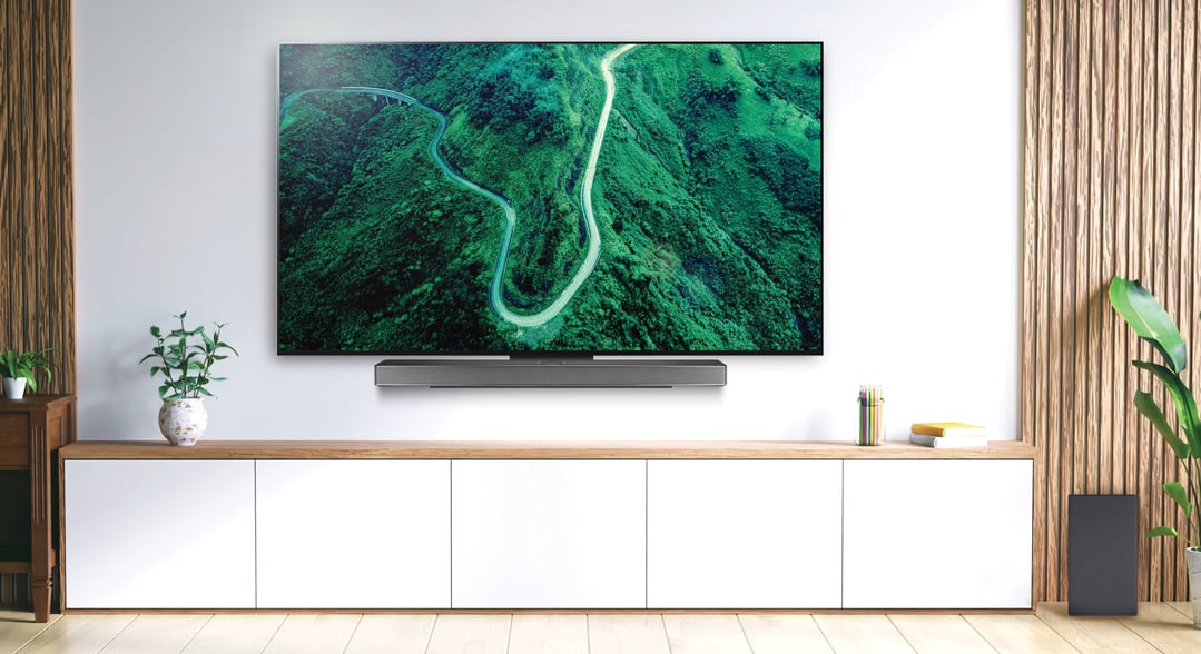 LG sound bar mounted below a TV in a modern living room setting