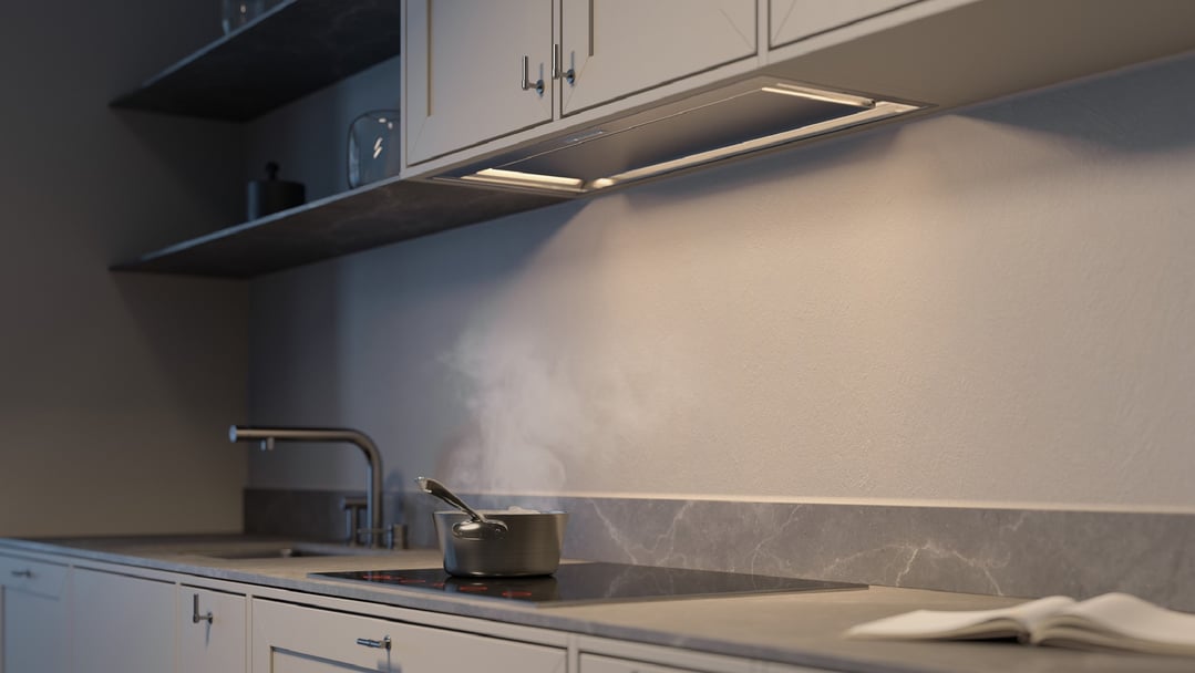 Concealed rangehood illuminating a pot steaming on an induction cooktop in a kitchen