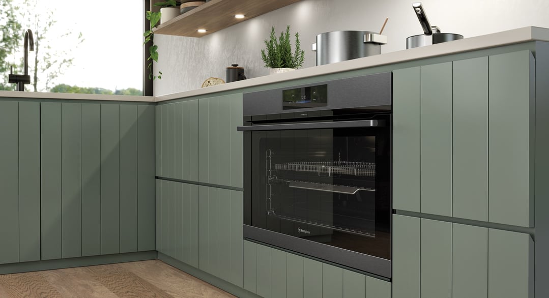 Built-in Westinghouse oven in a modern green kitchen with wooden floor