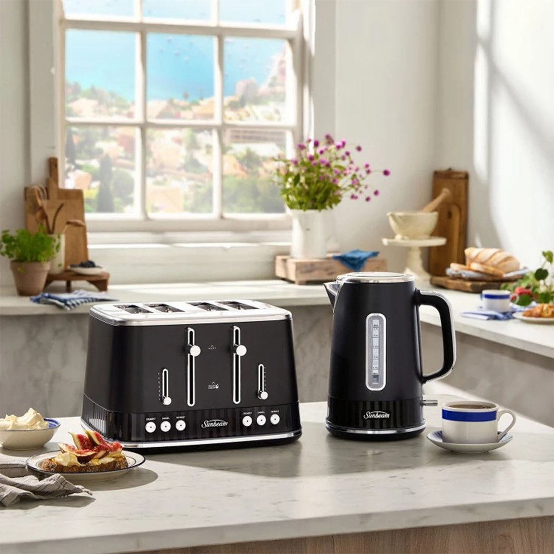 Black kettle and 4-slice toaster on a kitchen counter with breakfast items