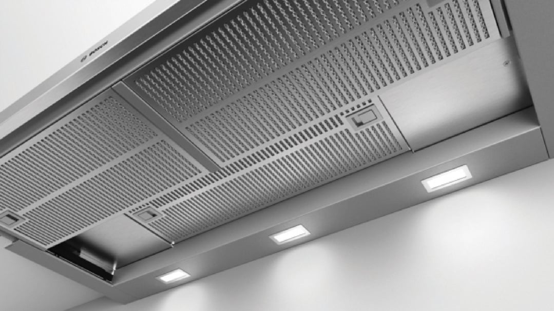 Underside view of a Bosch slideout rangehood with lights on