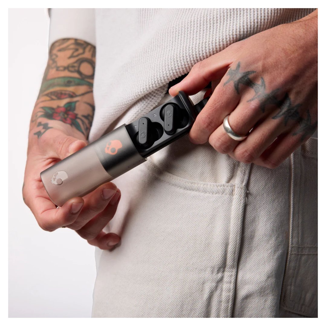 Person holding Skullcandy Dime Evo TWS in-ear headphones in a charging case