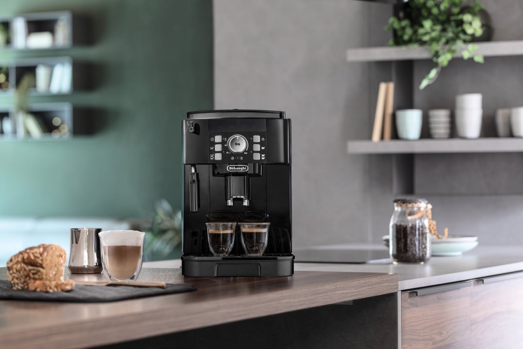 Black automatic coffee machine on a kitchen counter with two cups of coffee