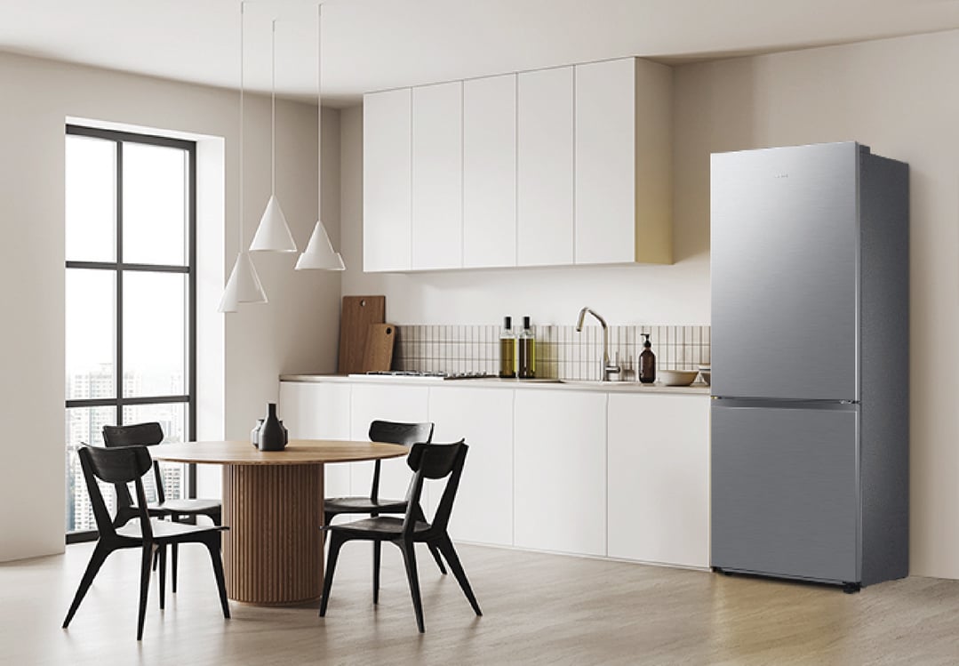 A silver Samsung refrigerator in a modern kitchen with a dining area