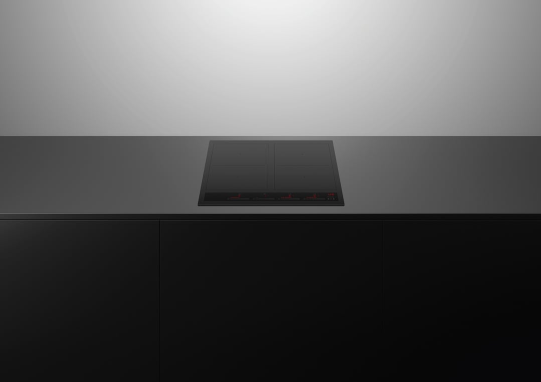 Black induction cooktop built into a dark countertop with black cabinetry below