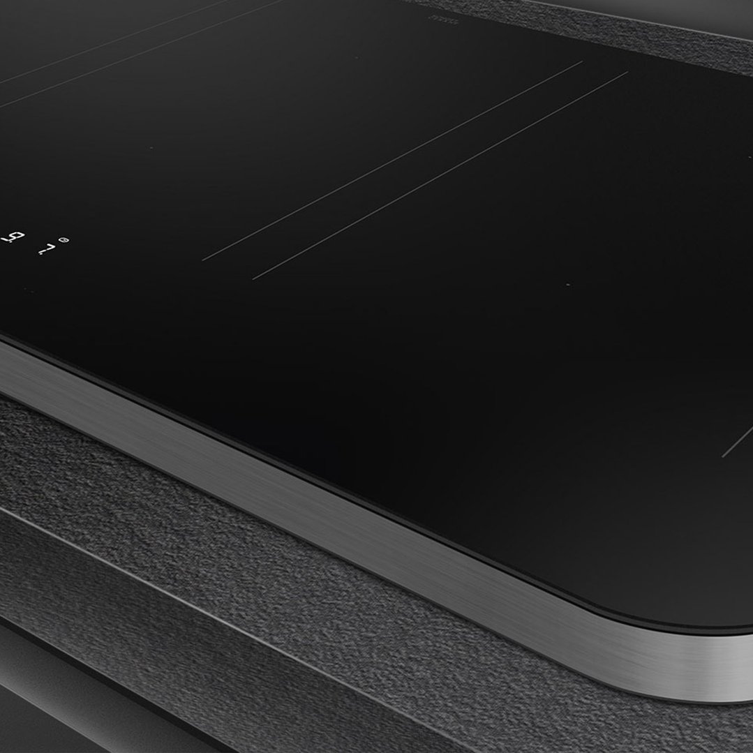 Close up of a black induction cooktop with a stainless steel trim