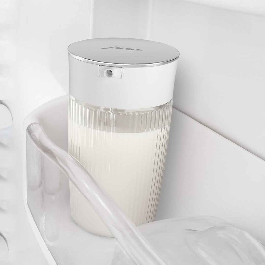JURA Milk Carafe filled with milk, placed inside a refrigerator door shelf