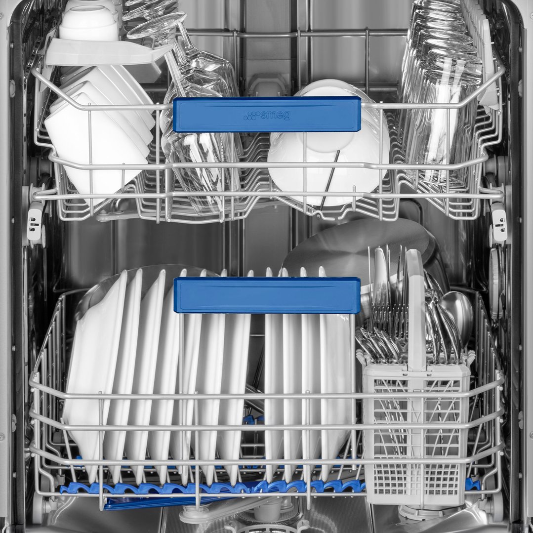 Close up of the inside of a dishwasher with dishes and cutlery
