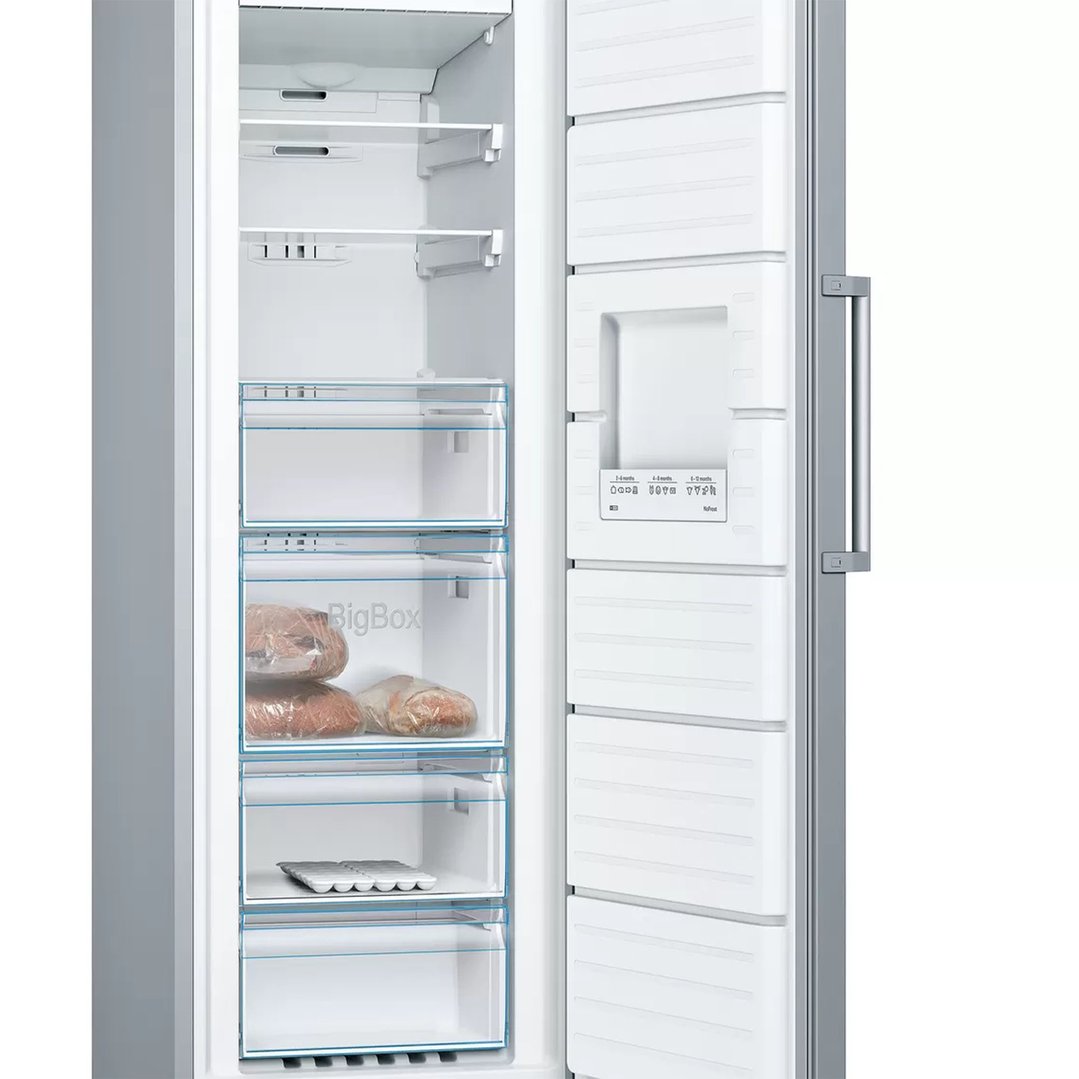 Open freezer showing multiple drawers with food items and an ice cube tray