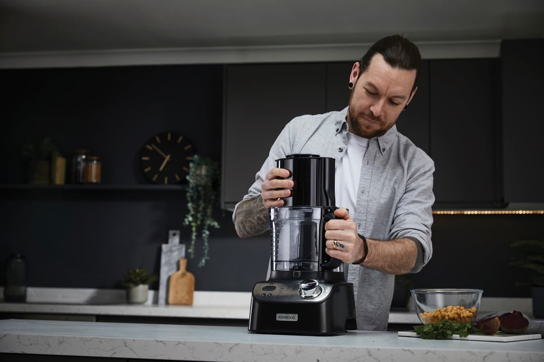 Man assembling a Kenwood MultiPro XL Weigh+ Food Processor on a kitchen counter