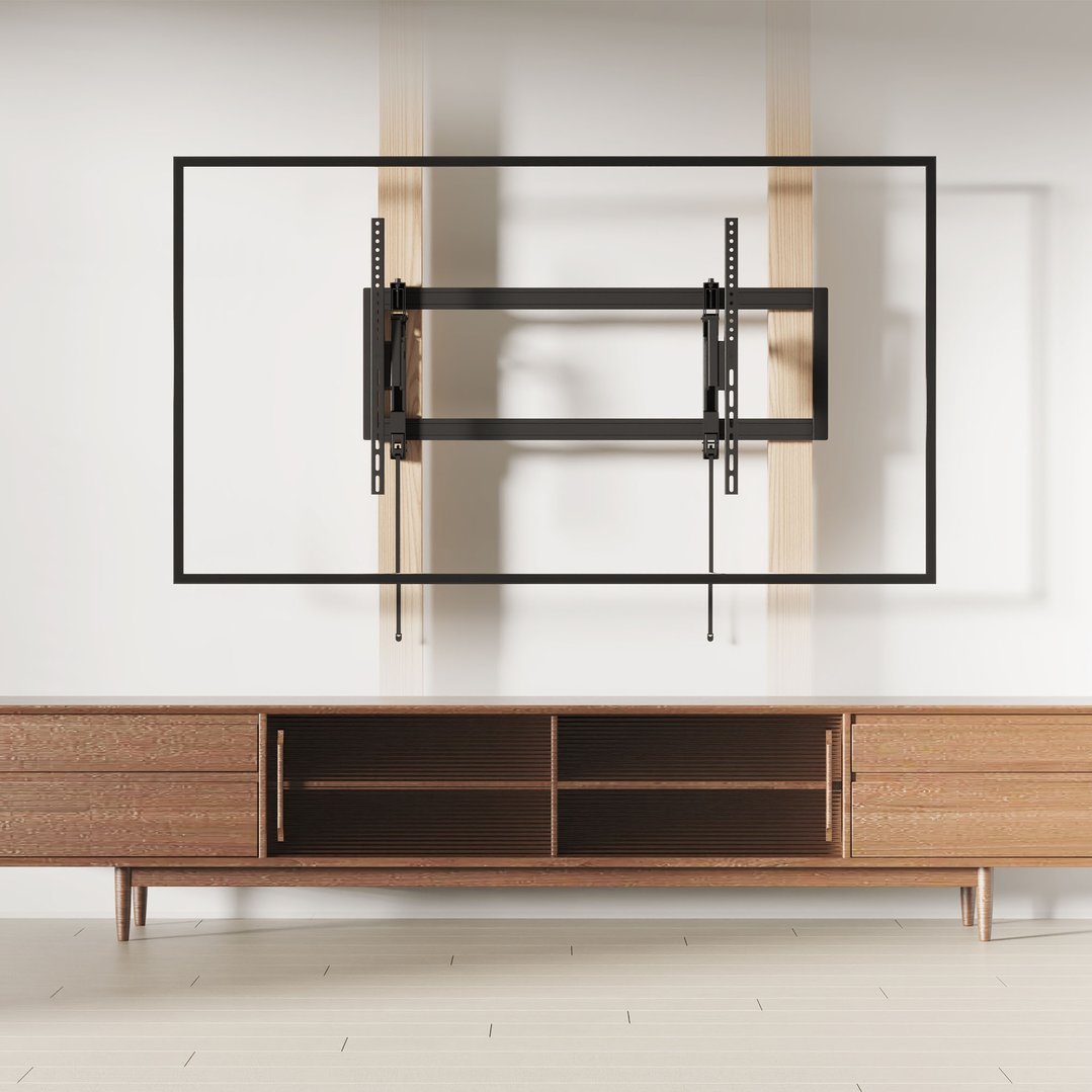 A tilting TV wall mount installed on a white wall above a wooden cabinet