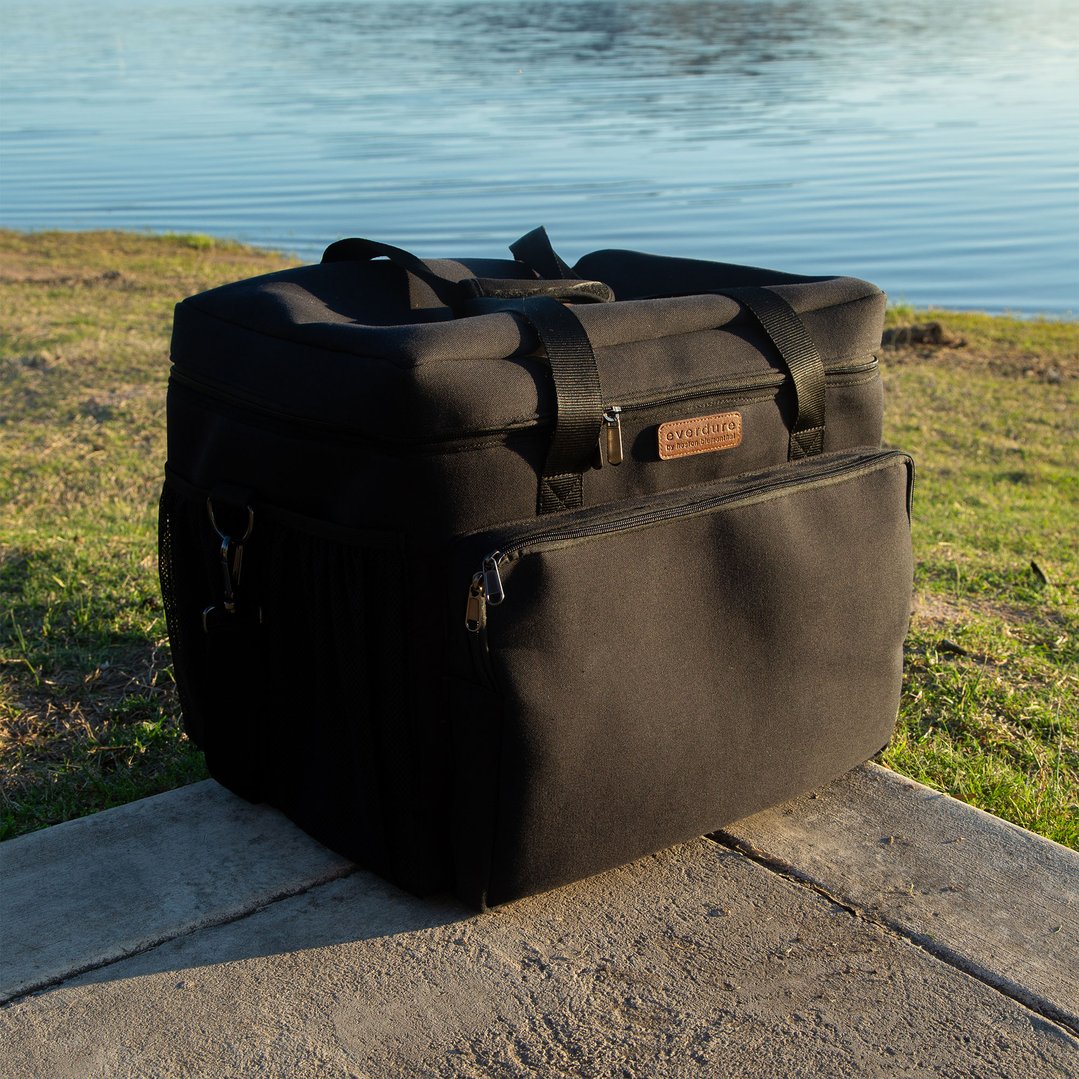 Black EVERDURE carrier bag on a concrete slab next to a lake
