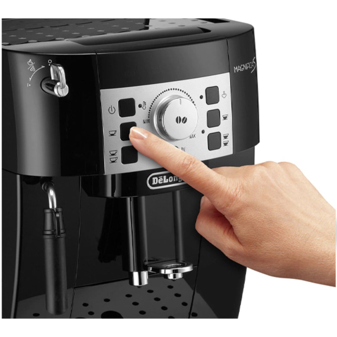 Hand pressing a button on a black fully automatic coffee machine