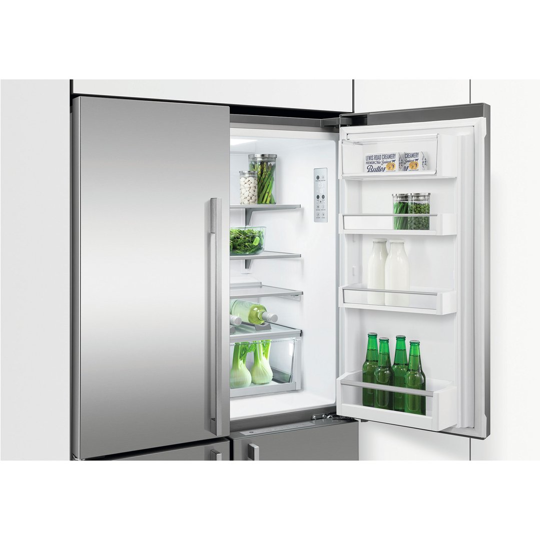 Open stainless steel quad door refrigerator freezer with food and drinks inside
