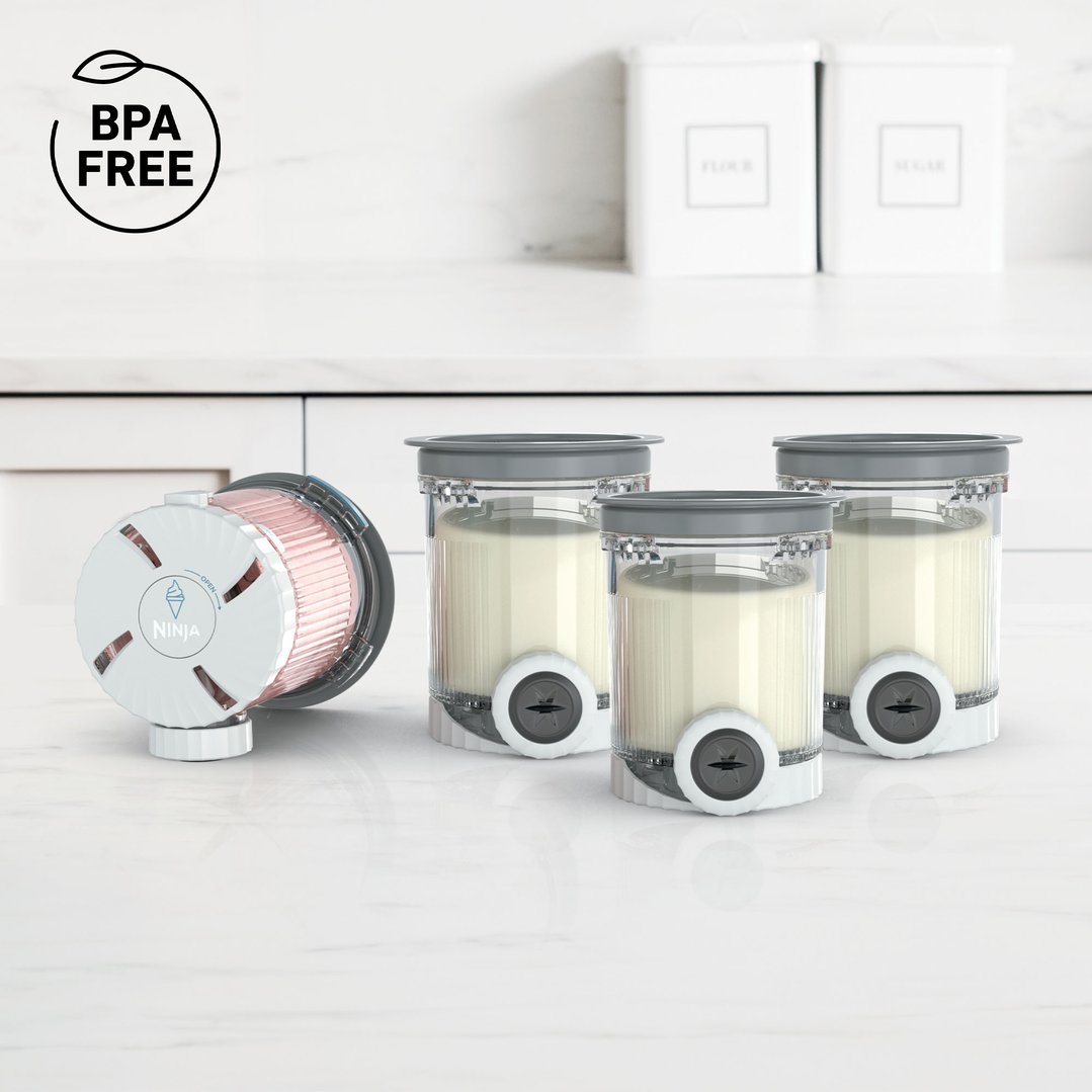 Ninja Creami tubs and lids on a white marble kitchen counter