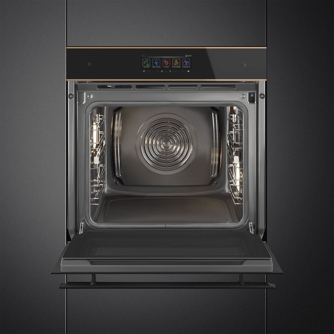 Black glass oven with copper trim, door open, built into dark cabinetry