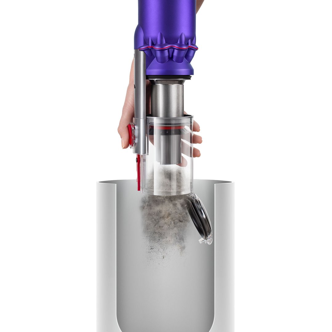 Hand emptying dust from a Dyson Omni-glide stick vacuum into a bin