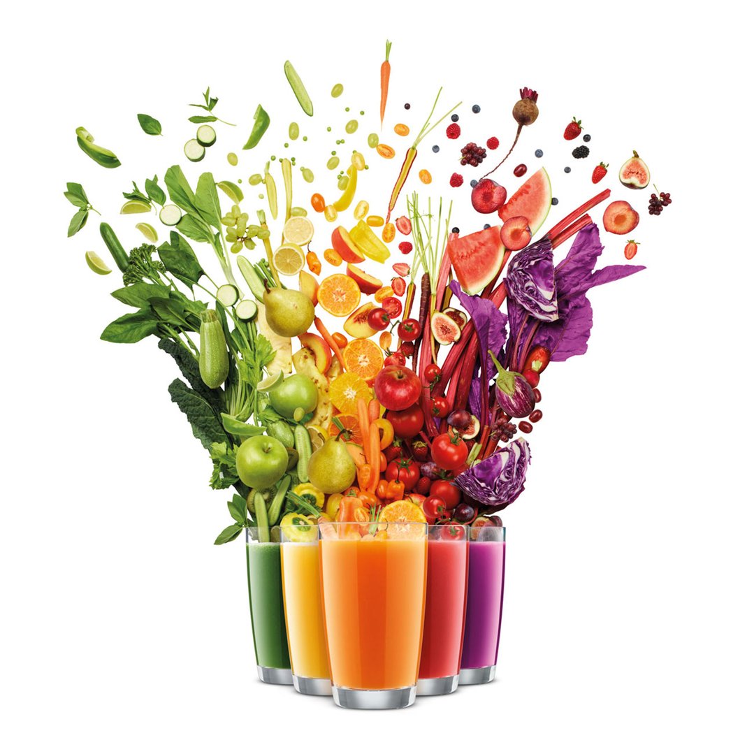 Rainbow of fruits and vegetables falling into five glasses of juice