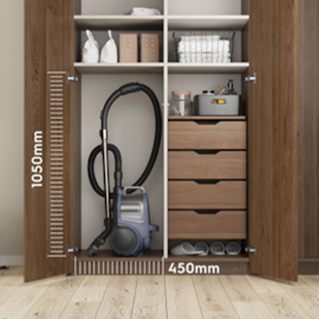 Bagless vacuum cleaner stored in a wooden wardrobe with shelves and drawers