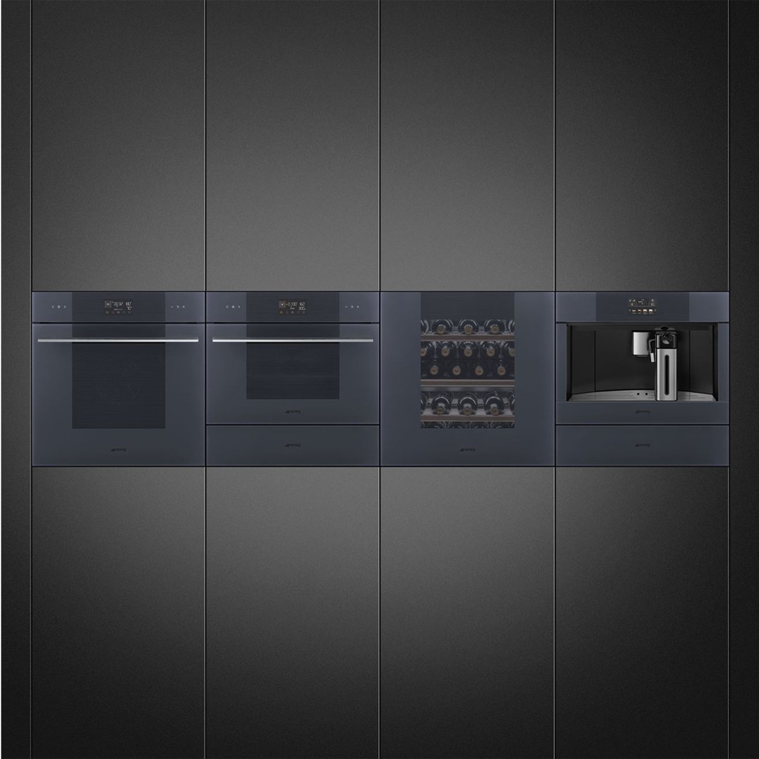 Four built-in appliances in a dark grey kitchen cabinet setting