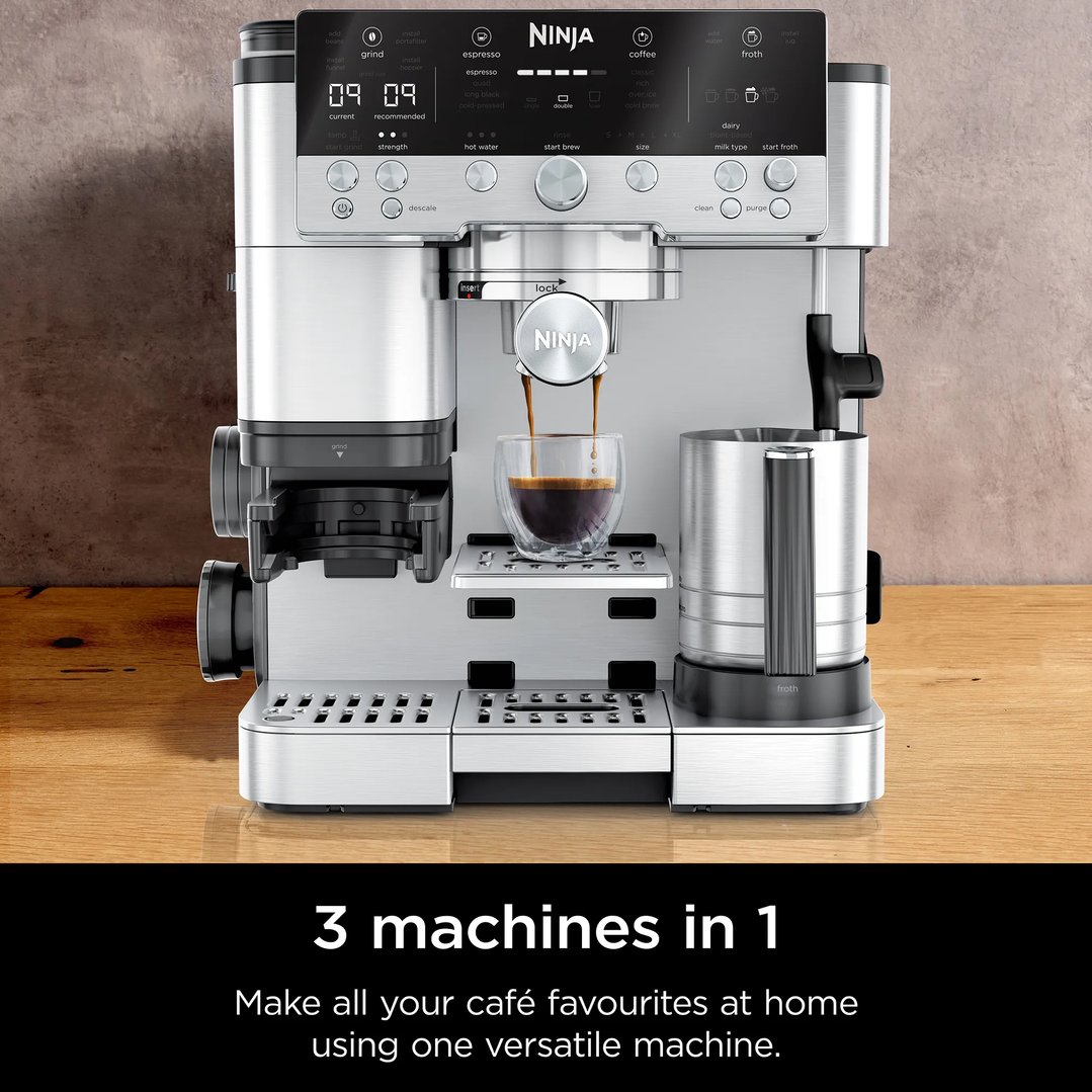 Ninja coffee machine brewing espresso into a glass cup on a wooden surface