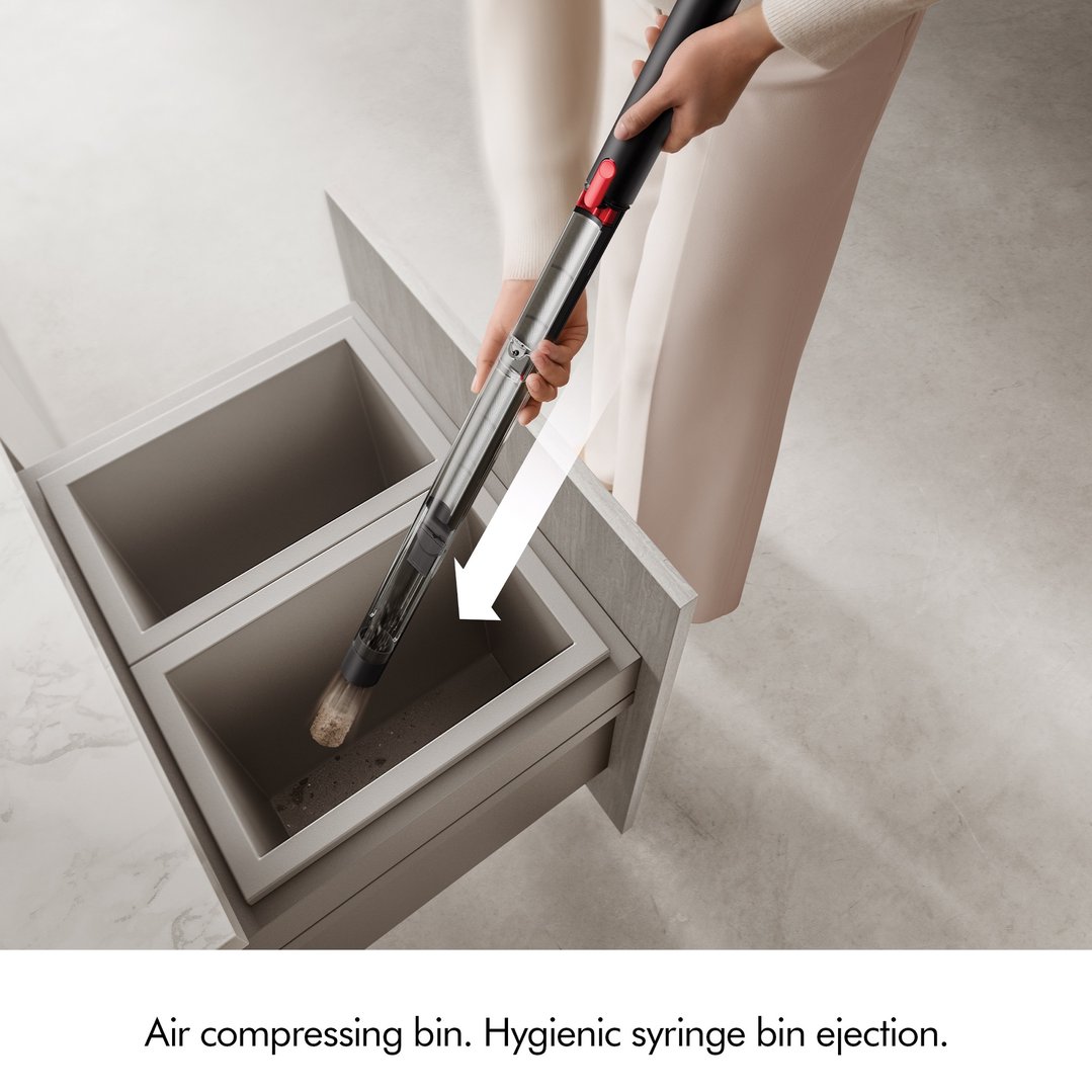Person emptying the hand stick vacuum cleaner into a bin