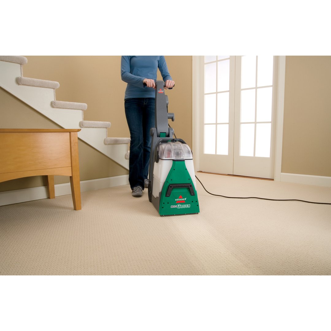 Woman using a BISSELL Big Green Deep Cleaning Machine on a carpeted floor