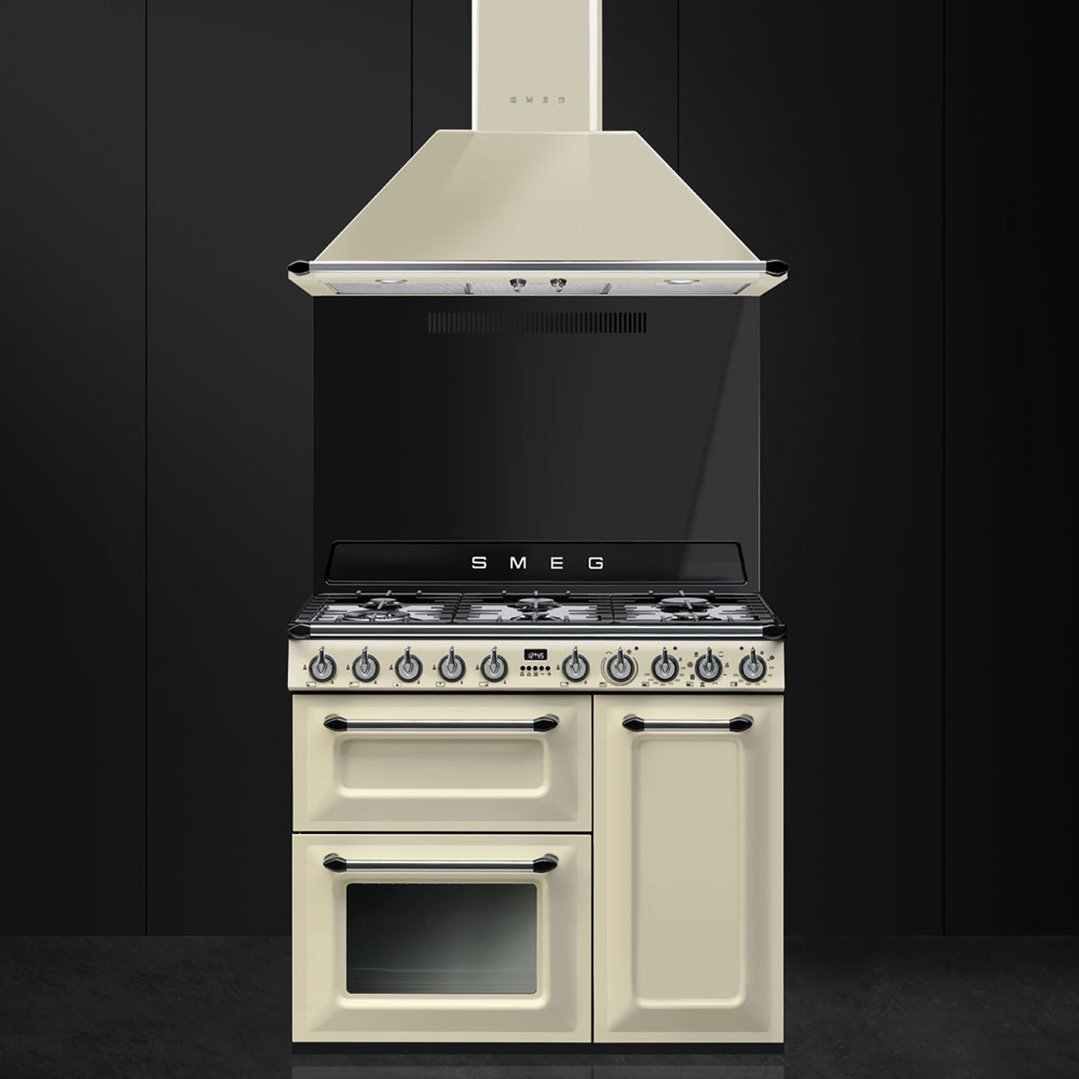 Cream freestanding cooker with matching rangehood against a dark background