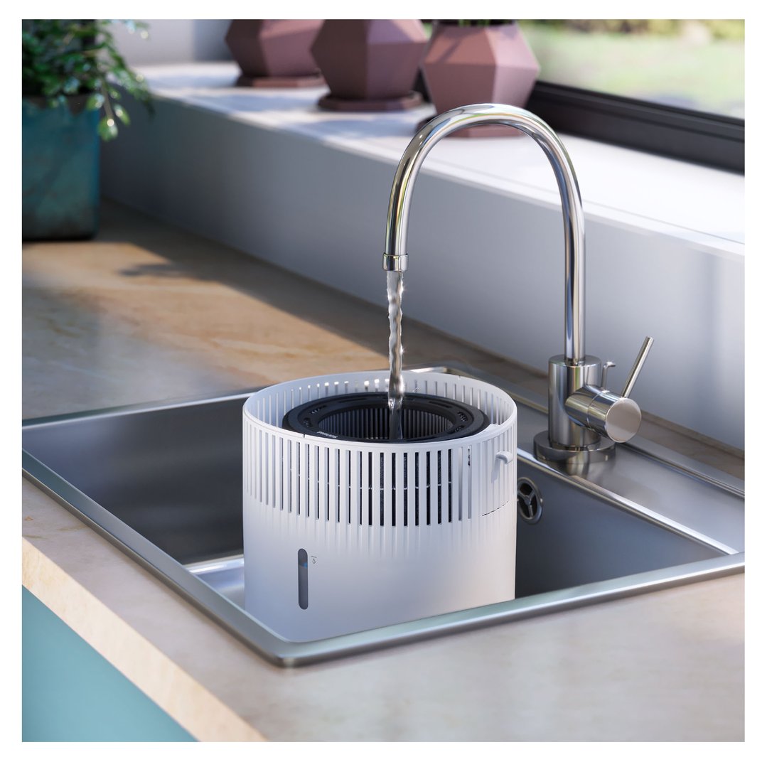 Humidifier being filled with water from a tap in a kitchen sink