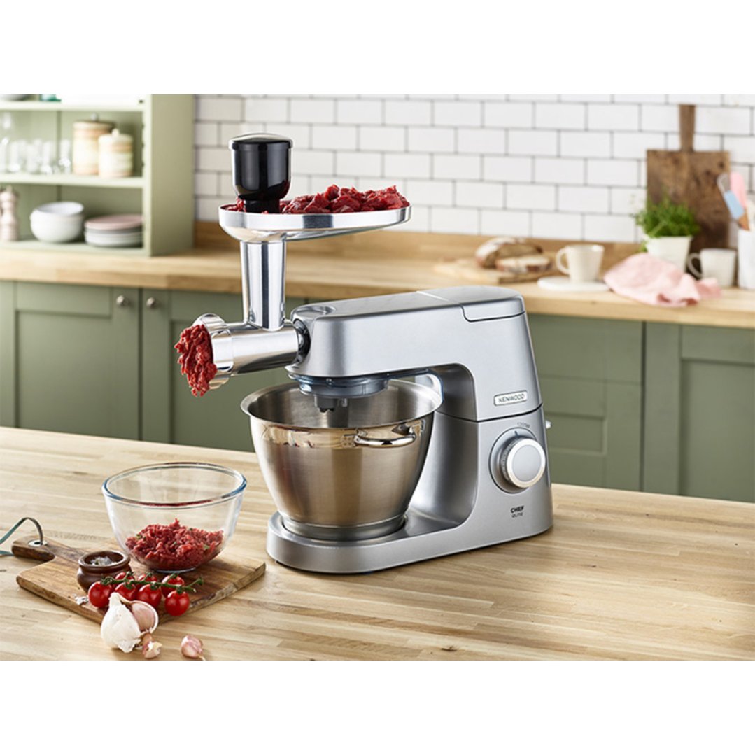 KENWOOD Food Grinder processing meat in a kitchen setting with ingredients nearby