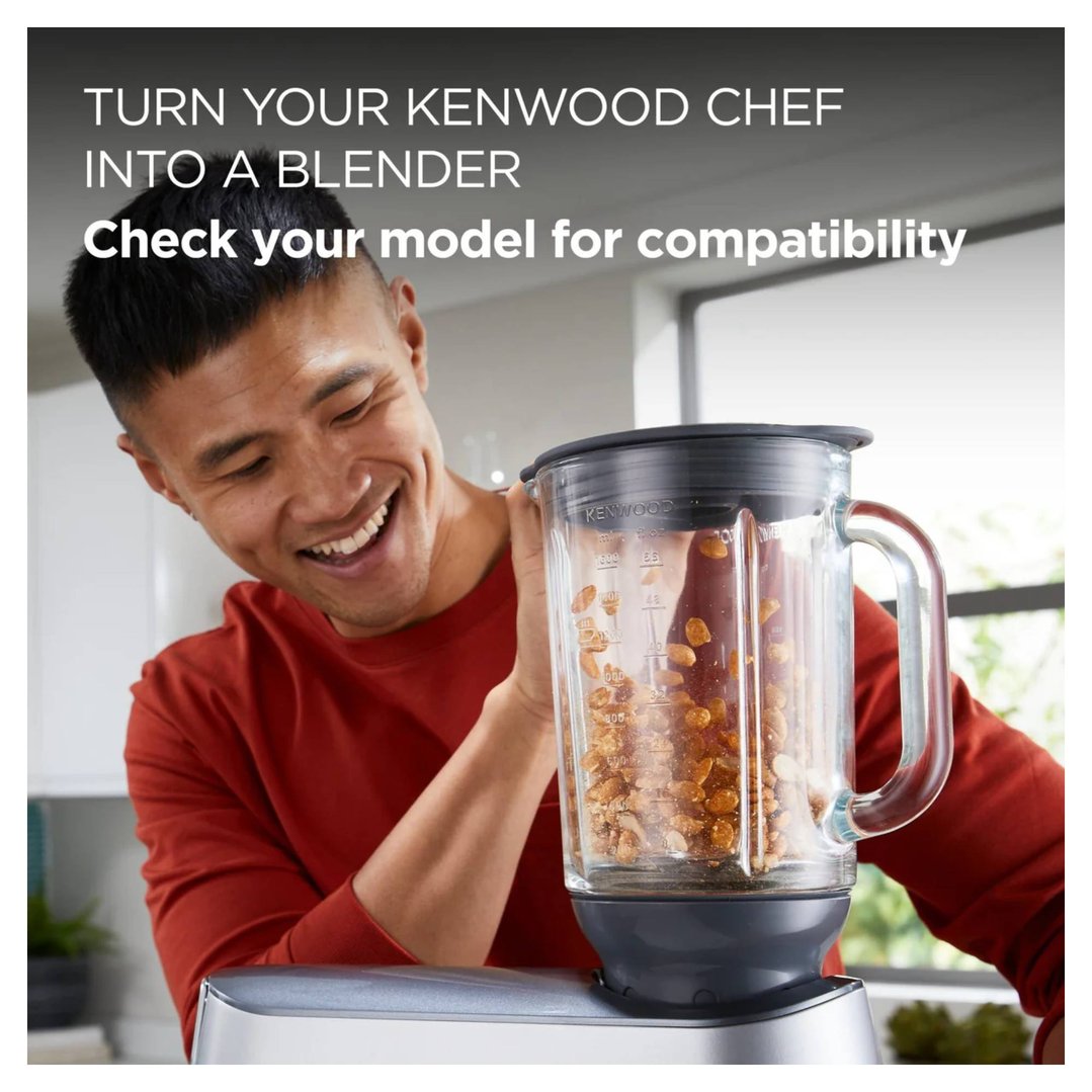 Man smiling while attaching a glass blender to a kitchen machine